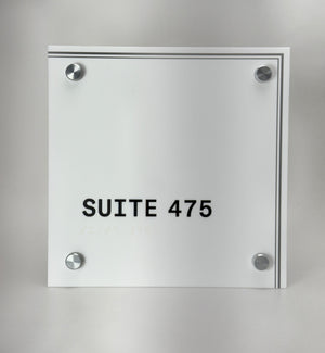 Glass nameplate with 'SUITE 475' text on a gray background