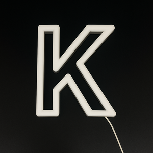 Neon light shaped like the letter 'K' on a black background