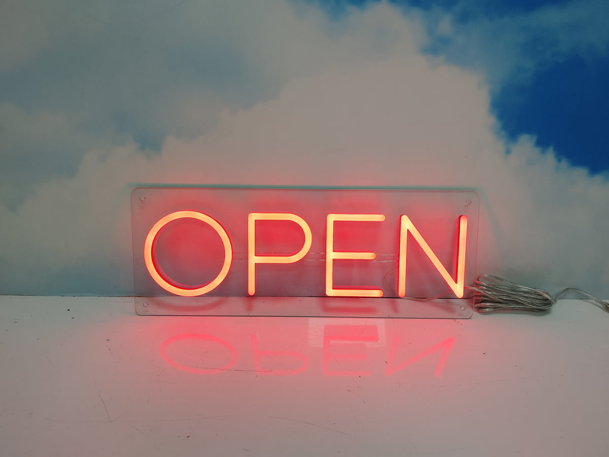 Neon 'OPEN' sign with a blue and white cloud background